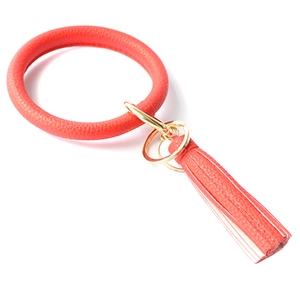 Detail of red PU leather bracelet keychain with tassel and golden metal hardware
