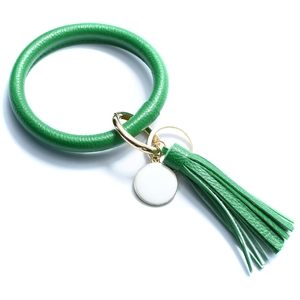Detail of green PU leather keyring bracelet with tassel charm and gold alloy hardware