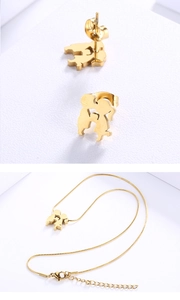 Close-up of gold-plated kissing couple necklace and earrings on white texture