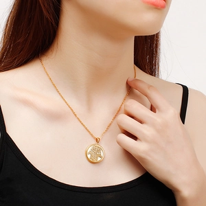 Collier doré en acier inoxydable avec pendentif main de Hamsa porté par un mannequin