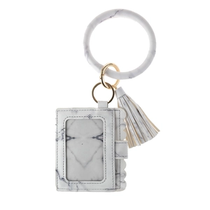 Macro view of white marble silicone bangle and leather card wallet with gold hardware