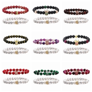 Close-up of beaded stone bracelets set with crystal crown charms in various colors
