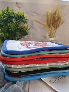 Detail shot of multi-color thick cotton oven pads with premium piping and lobster print
