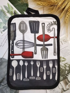 Detail of a thick cotton kitchen insulation pad with printed cutlery pattern and hanging loop
