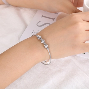 Gros plan d'un bracelet en acier argenté avec perles serties de diamants et perle nacrée