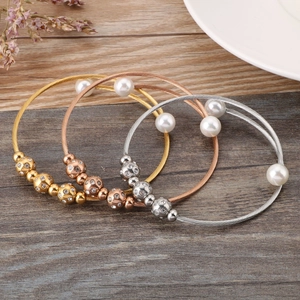 Three-piece stainless steel cable bracelets in gold, rose gold, and silver with pearls
