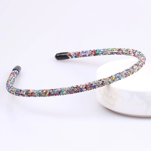 Detailed macro view of thin rainbow rhinestone headband with smooth black end tips