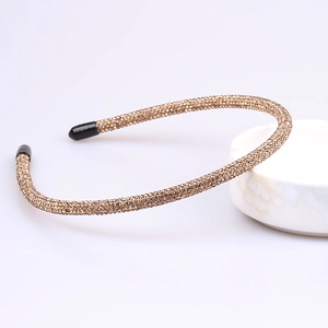 Detail shot of golden rhinestone headband showing sparkling crystals and non-slip pads