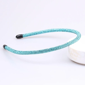 Detailed close-up of slim metal headband with blue rhinestones and protective ear tips