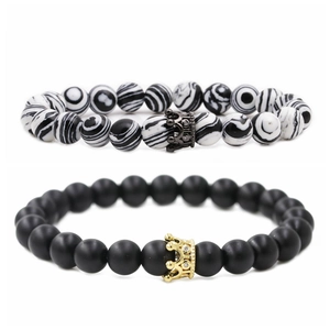 Malachite and matte lava stone beaded couple bracelets with crown charms on white background