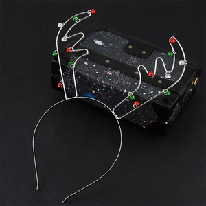 Detailed close-up of silver metal reindeer antler headband with red and green bells
