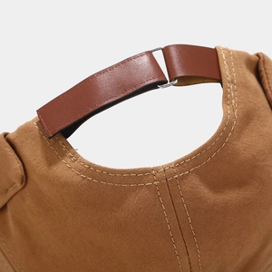 Détail du bonnet docker en toile kaki avec bride de réglage en cuir marron au dos