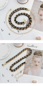 Close-up of woven gold chain belt with black ribbon and adjustable lobster clasp