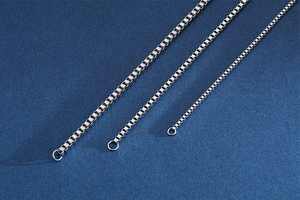 Detailed view of three different thicknesses of silver stainless steel box chains
