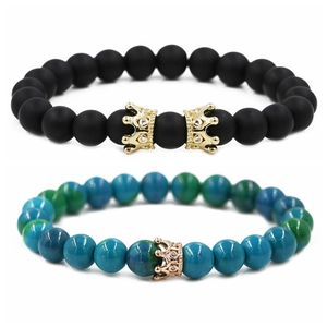 Bracelets en perles de pierre noire mate et bleu-vert avec des couronnes dorées