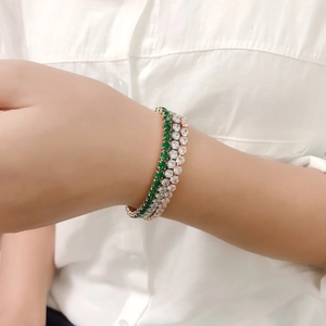 Bracelets tennis réglables en or rose avec cristaux verts et blancs portés par mannequin