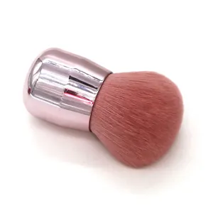 Detail of pink retractable makeup brush with dense bristles and metallic pink handle