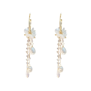 Elegant gold-tone long drop earrings with white floral accents and crystal tassel detail