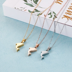 Three dolphin necklaces in gold, rose gold and silver finishes on a gift box