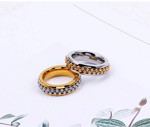 Close-up of interlocking beaded stress rings in gold and silver stainless steel