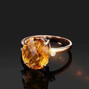 Macro view of oval yellow gemstone ring in rose gold with brilliant side stones