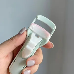 Portable mint green eyelash curler with pink rubber pad for long-lasting curling