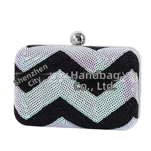 Detail of wave-patterned sequin clutch bag with silver metal frame and ball clasp