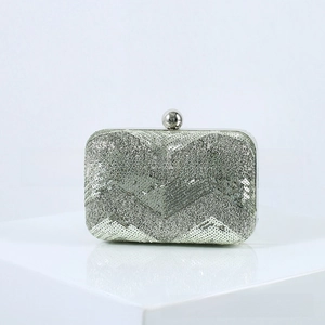 Detail of silver sequin evening clutch with herringbone pattern and spherical clasp