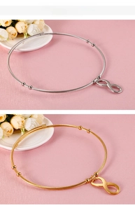 Detail of infinity symbol steel wire bracelets in gold and silver finishes with adjustable beads