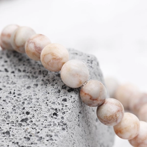 Macro detail of natural stone beads with reddish textures on an inspirational bracelet