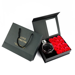 Detail of luxury black gift box with red soap roses, gift bag and perfume bottle set