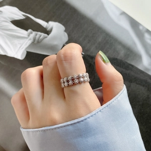 Detail shot of a minimalist 925 sterling silver ring with delicate daisy flower patterns