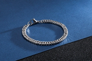 Close-up of silver stainless steel Cuban link chain showing polished metal texture and clasp