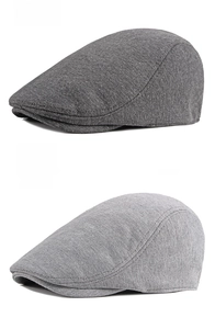 Close-up of dark and light gray knitted beret flat caps showing fine fabric textures