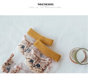 Detail of transparent mesh socks featuring cute cat patterns and yellow ribbed cuffs