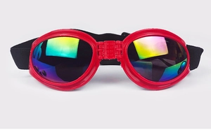 Detail of red pet goggles featuring colorful reflective lenses and adjustable elastic strap