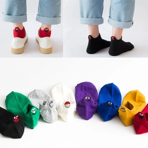 Detail of colorful cotton socks featuring diverse cartoon emoji embroidery on heels