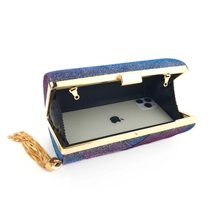 Dettaglio della pochette in raso iridescente con nappe dorate e spazio per il cellulare