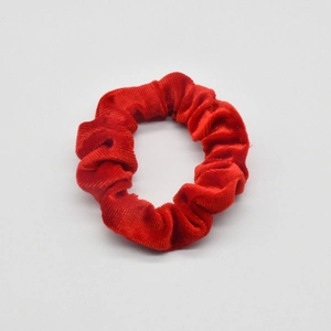 Detail of red velvet scrunchie showing soft fabric texture and ruffled design