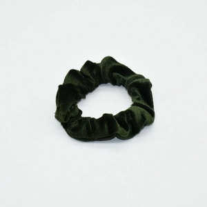 Detail shot of a dark green velvet scrunchie showing fabric texture and elastic design