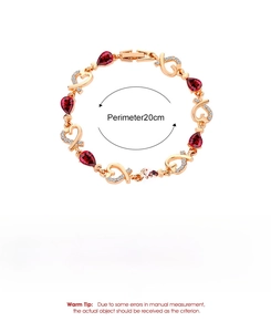 Detailed view of rose gold bracelet featuring red pear-shaped stones and crystal hearts