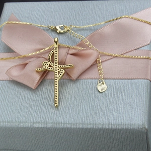Elegant gold ballerina pendant necklace with black stones in a grey ribbon gift box