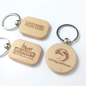 Detailed close-up of natural beech wood keychains with custom engraved logos and text