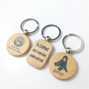 Detail of round and rectangular beech wood keychains with smooth texture and metal rings
