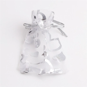 Detail view of white organza gift bag with silver foil heart patterns and drawstring