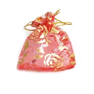 Red organza jewelry pouch with gold rose pattern and drawstring closure on white background