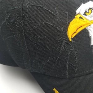 Dettaglio del ricamo dell'aquila su berretto da baseball in cotone nero con trama saia