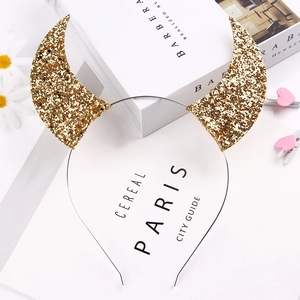 Detail of golden sequined devil horn headband with fine metal frame on clean background
