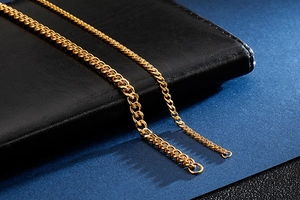 Close-up of golden stainless steel Cuban link chains in two different thicknesses