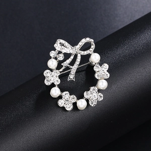Elegant silver sunflower brooch with pearls, rhinestones, and a crystal bow accent